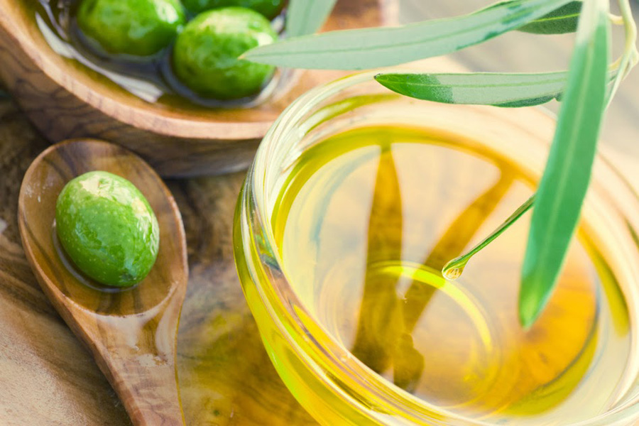 Extra virgin healthy Olive oil with fresh olives on rustic wooden background